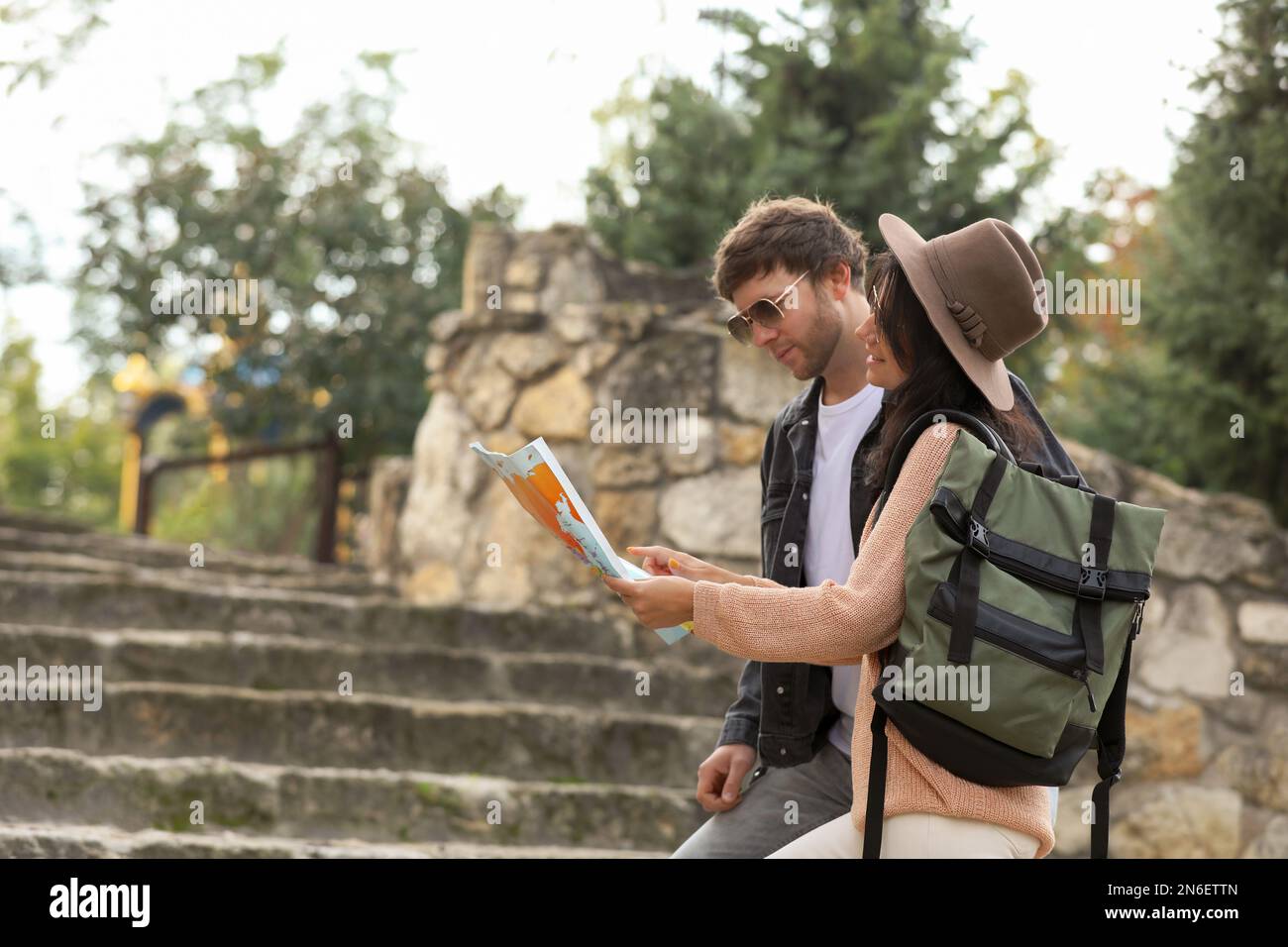 Couple of travelers with map on city street Stock Photo