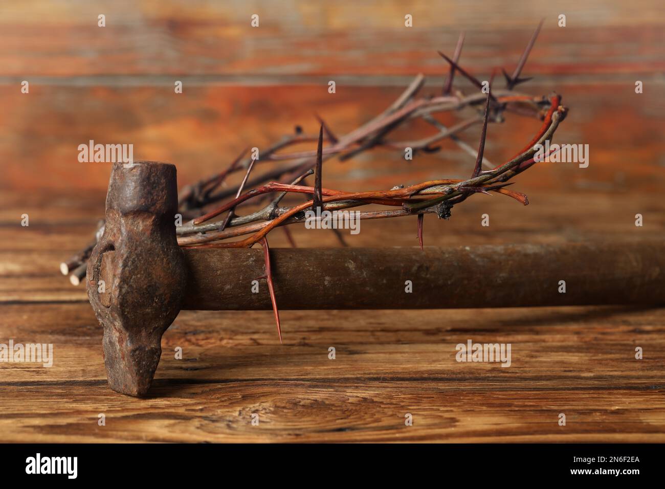 Crown of thorns and hammer on wooden table. Easter attributes Stock Photo