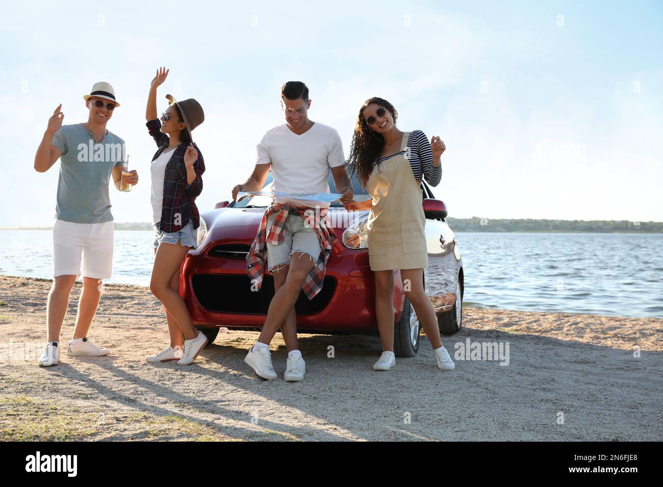 Happy friends having fun near car on beach. Summer trip Stock Photo - Alamy