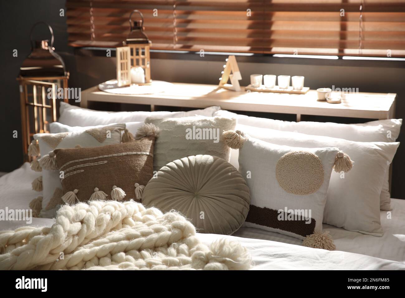 Cozy bedroom interior with knitted blanket and cushions Stock Photo - Alamy