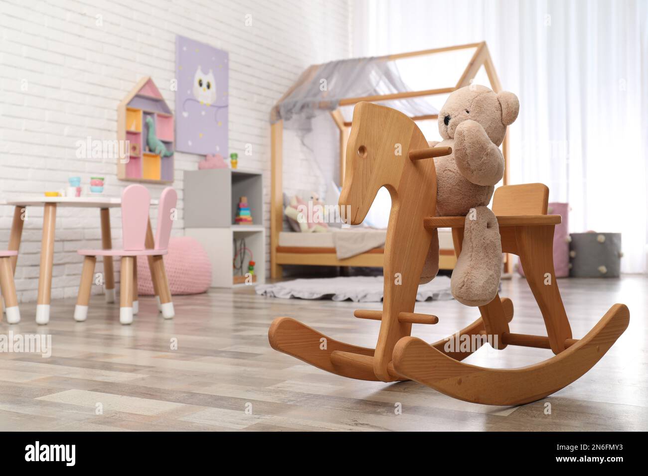 Teddy bear on wooden rocking horse in child's room, space for text ...