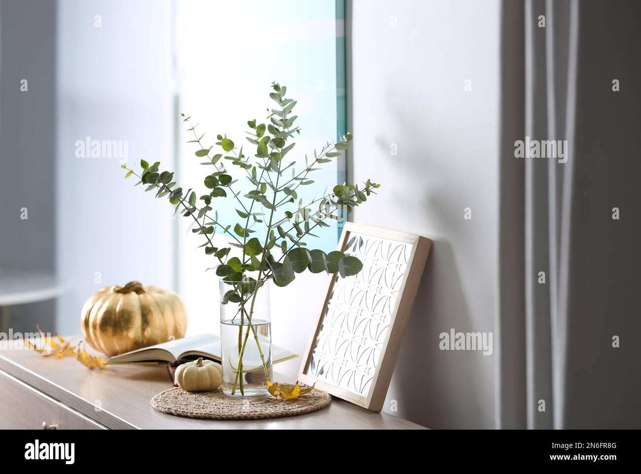 Beautiful eucalyptus branches and decor on cabinet in modern room ...