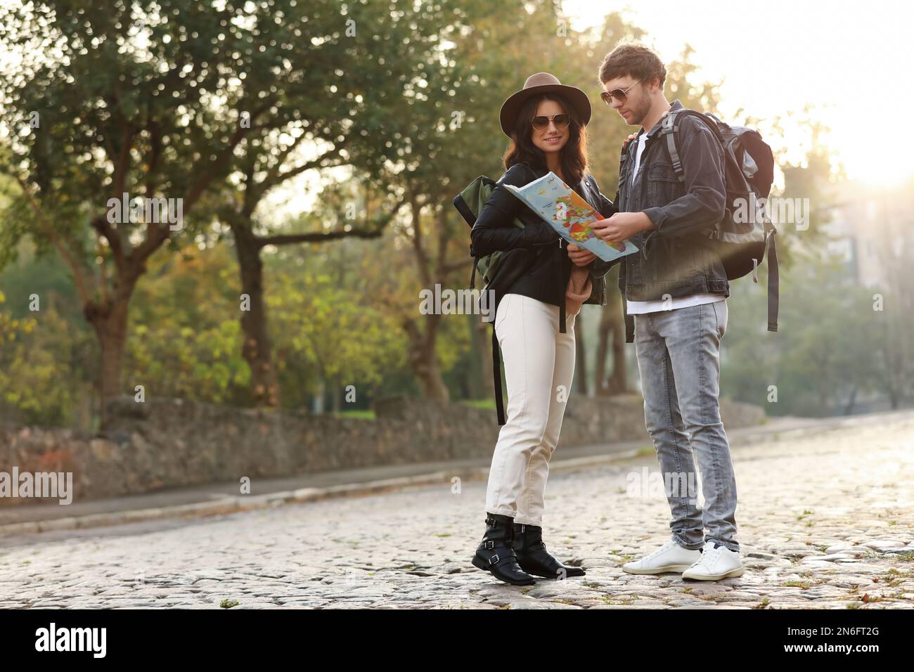 Couple of travelers with map on city street Stock Photo