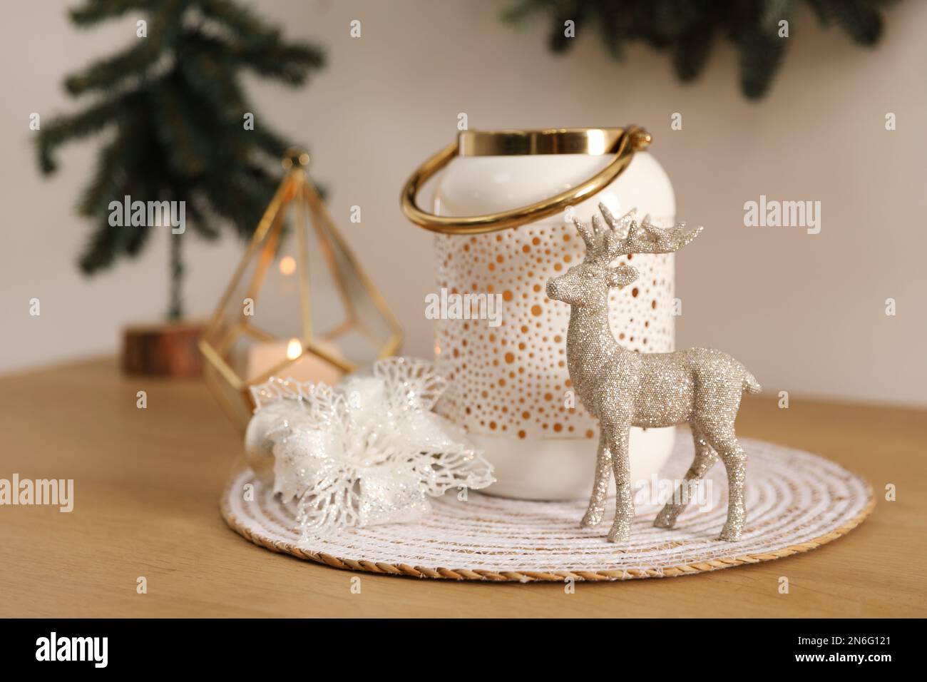 Small shiny deer, decorative flower and candle holder on wooden table. Interior design Stock Photo