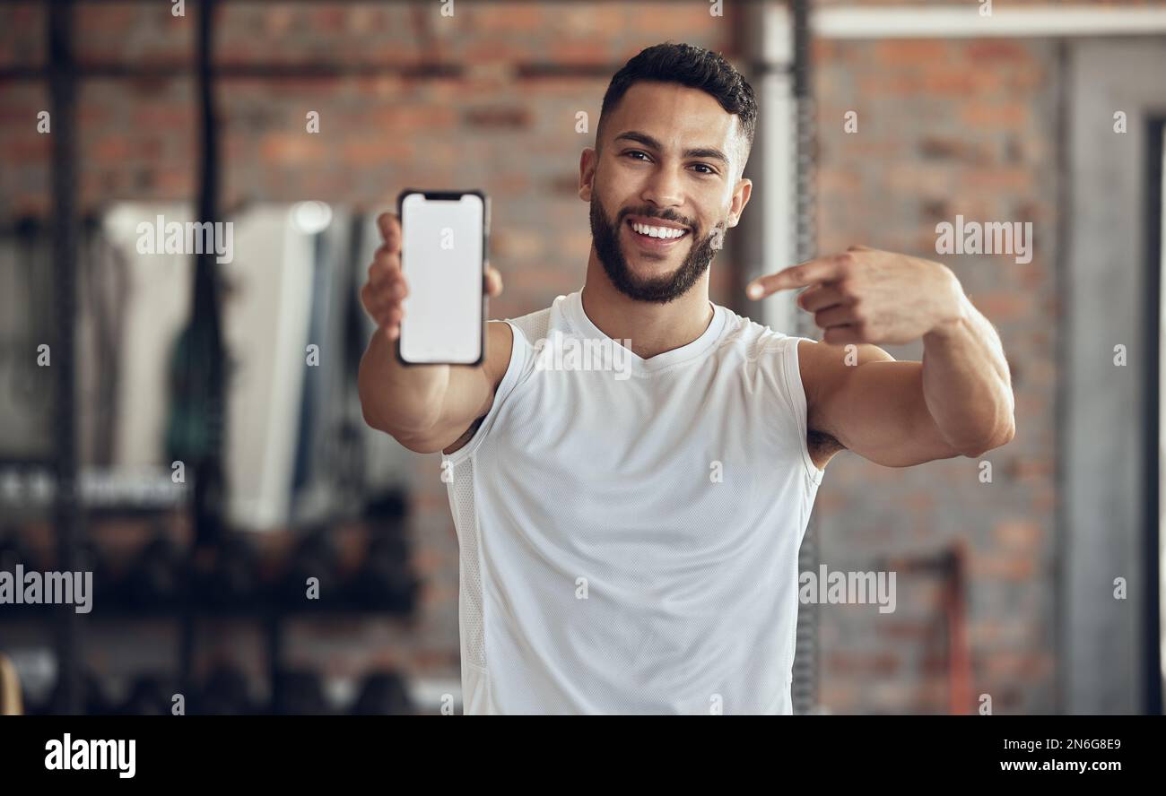 Fit young man showing his smartphone screen. Muscular bodybuilder using ...