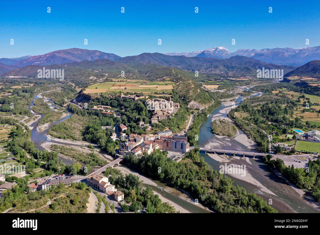 Drone shot, aerial view of the new town of Ainsa and the rivers Rio Cinca and Ara, behind it the historic old town of Ainsa and the mountains of the Stock Photo