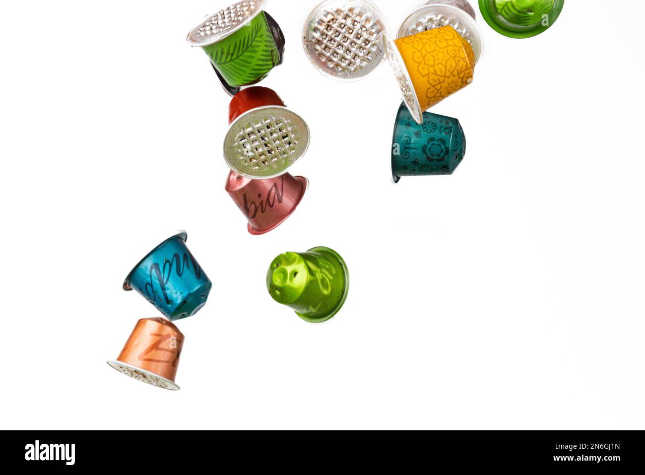 https://c8.alamy.com/comp/2N6GJ1N/different-coloured-used-coffee-capsules-flying-white-background-2N6GJ1N.jpg