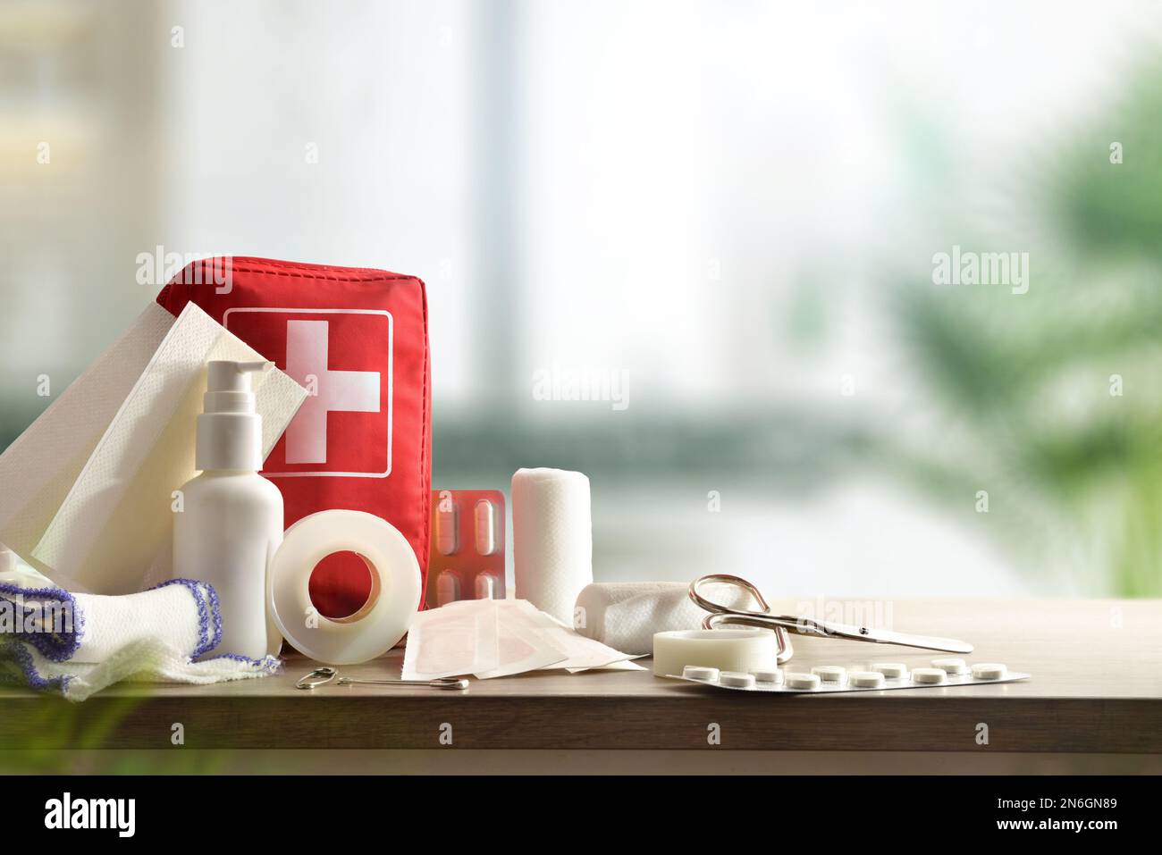 Emergency home kit on wooden table and warm room background. Horizontal composition. Front view. Stock Photo