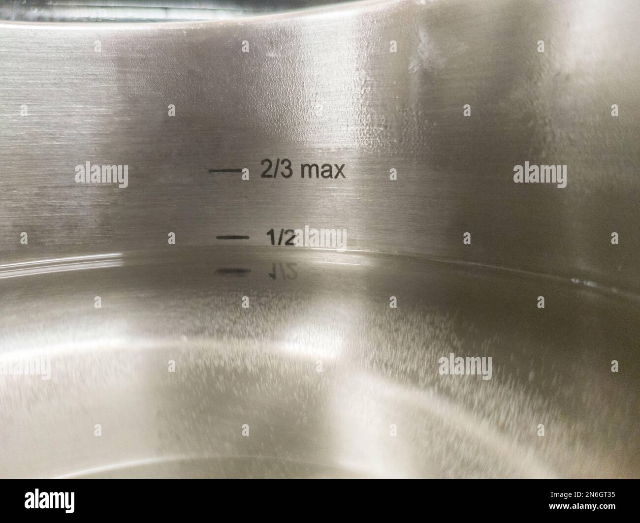 Stainless Steel Pressure Cooker at work. Liquid level markings Stock