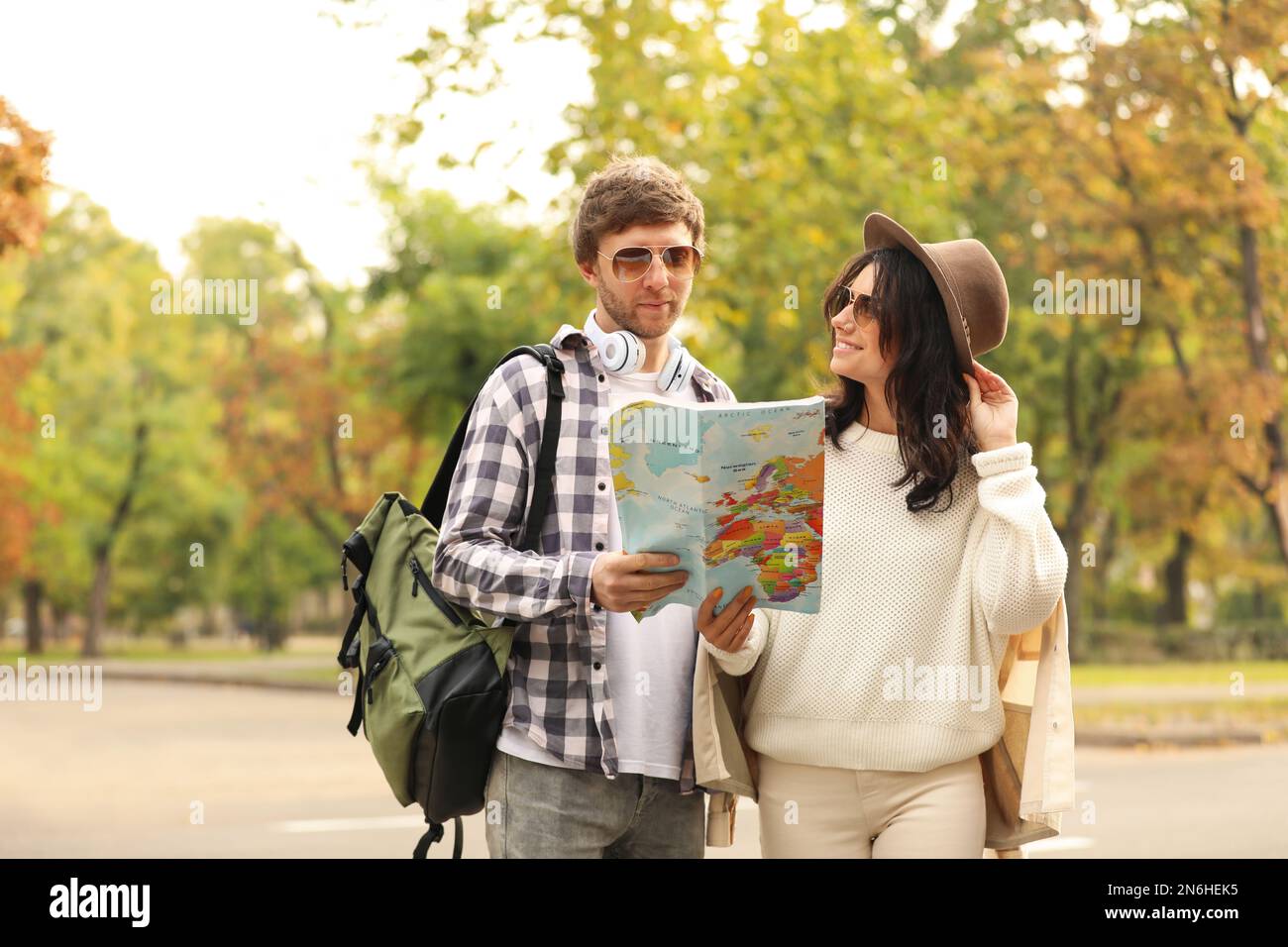 Couple of travelers with map on city street Stock Photo