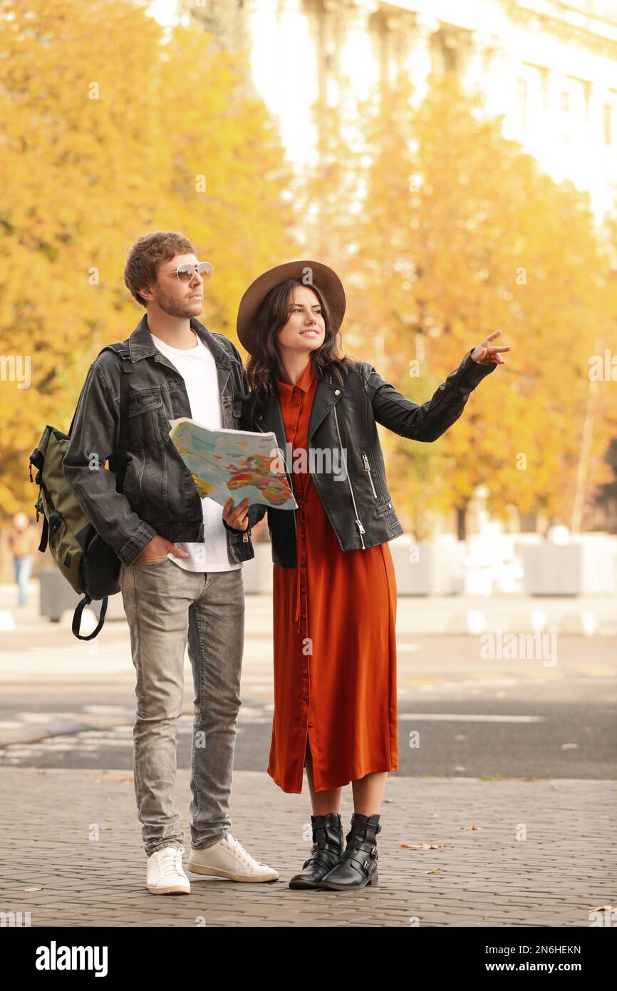 Couple of travelers with map on city street Stock Photo