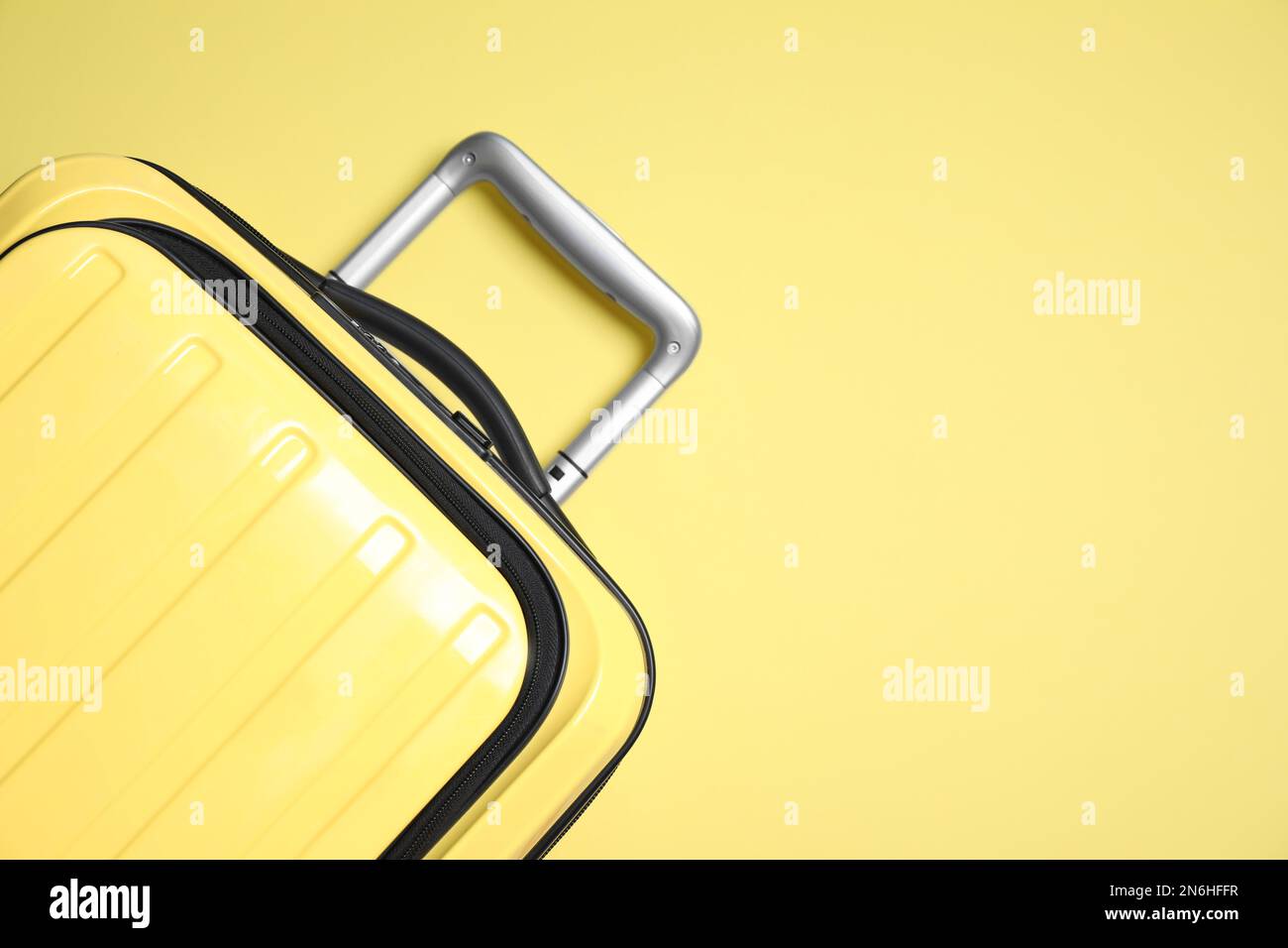 Modern suitcase on yellow background, top view Stock Photo