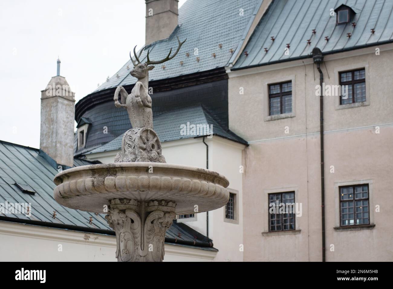 The fountain with an armorial symbol of Palffy family in the courtyard of Cerveny Kamen castle, Slovakia Stock Photo