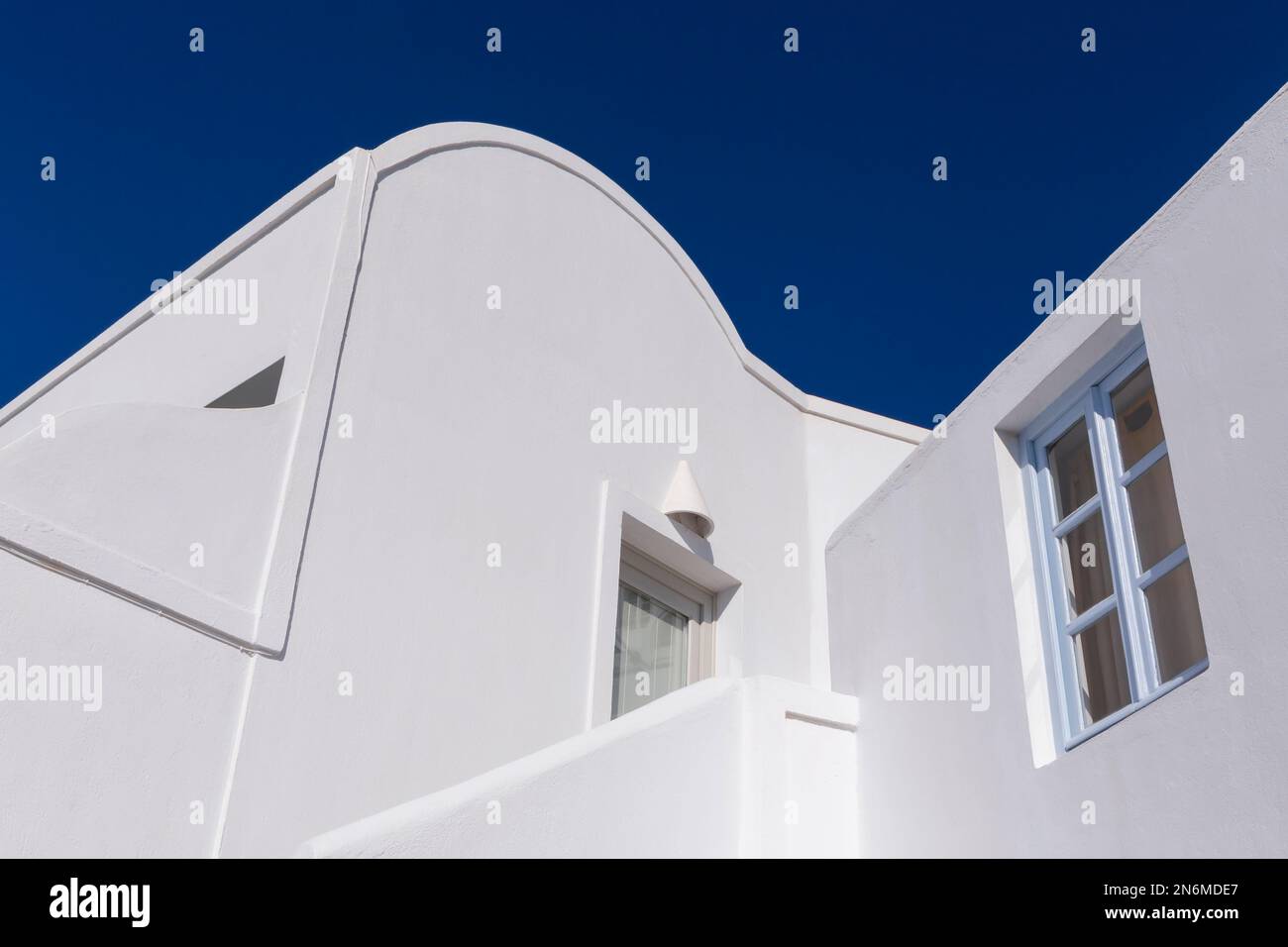 traditional white building on Santorini island in Greece against blue sky Stock Photo