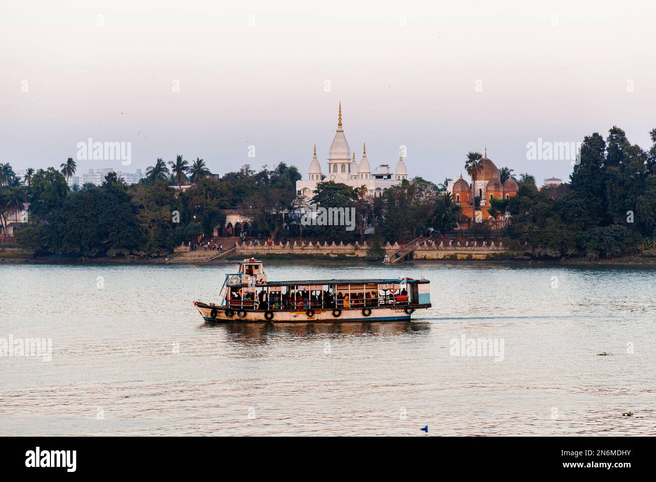 Local passenger ferry by ISKCON Panihati Hindu temple on the bank of the Hooghly River, Khardaha, by Panihati Ferry Ghat, Calcutta, West Bengal, India Stock Photo