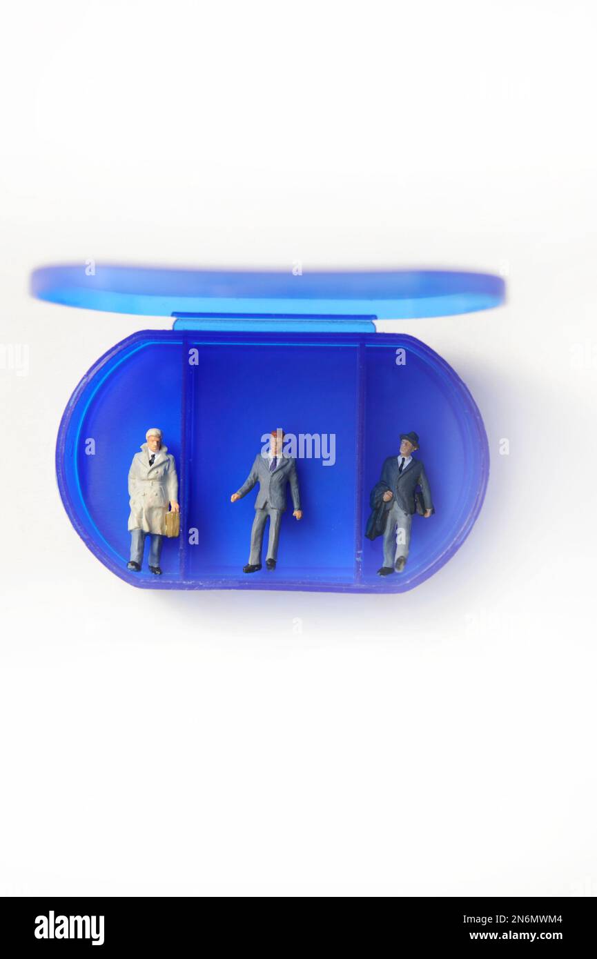 blue plastic box with compartments and miniature figurines of people inside Stock Photo