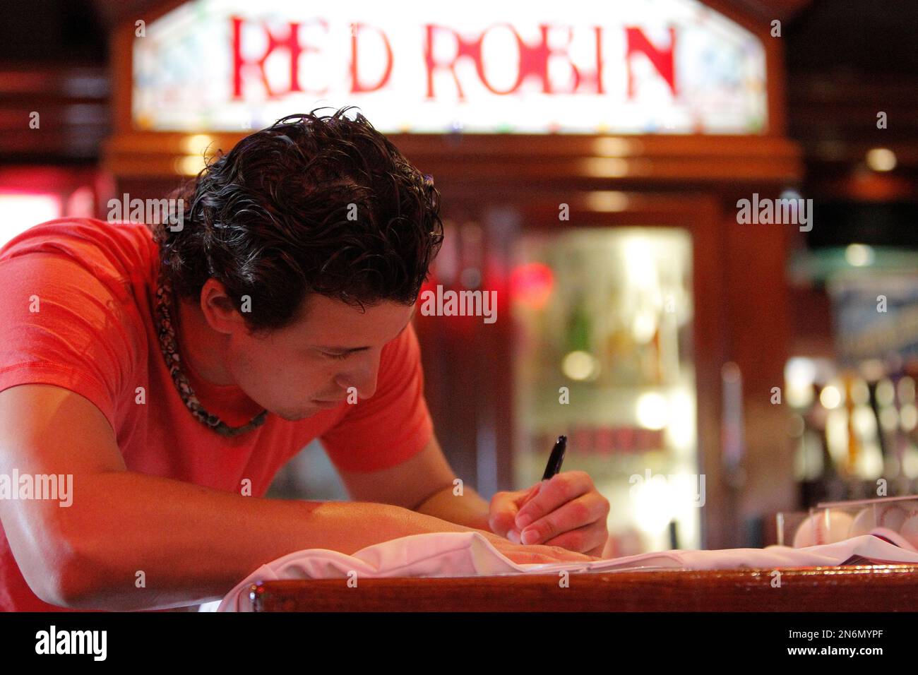 Red Robin bartender Brian Tillotson, left, watches as Texas MLB pitcher