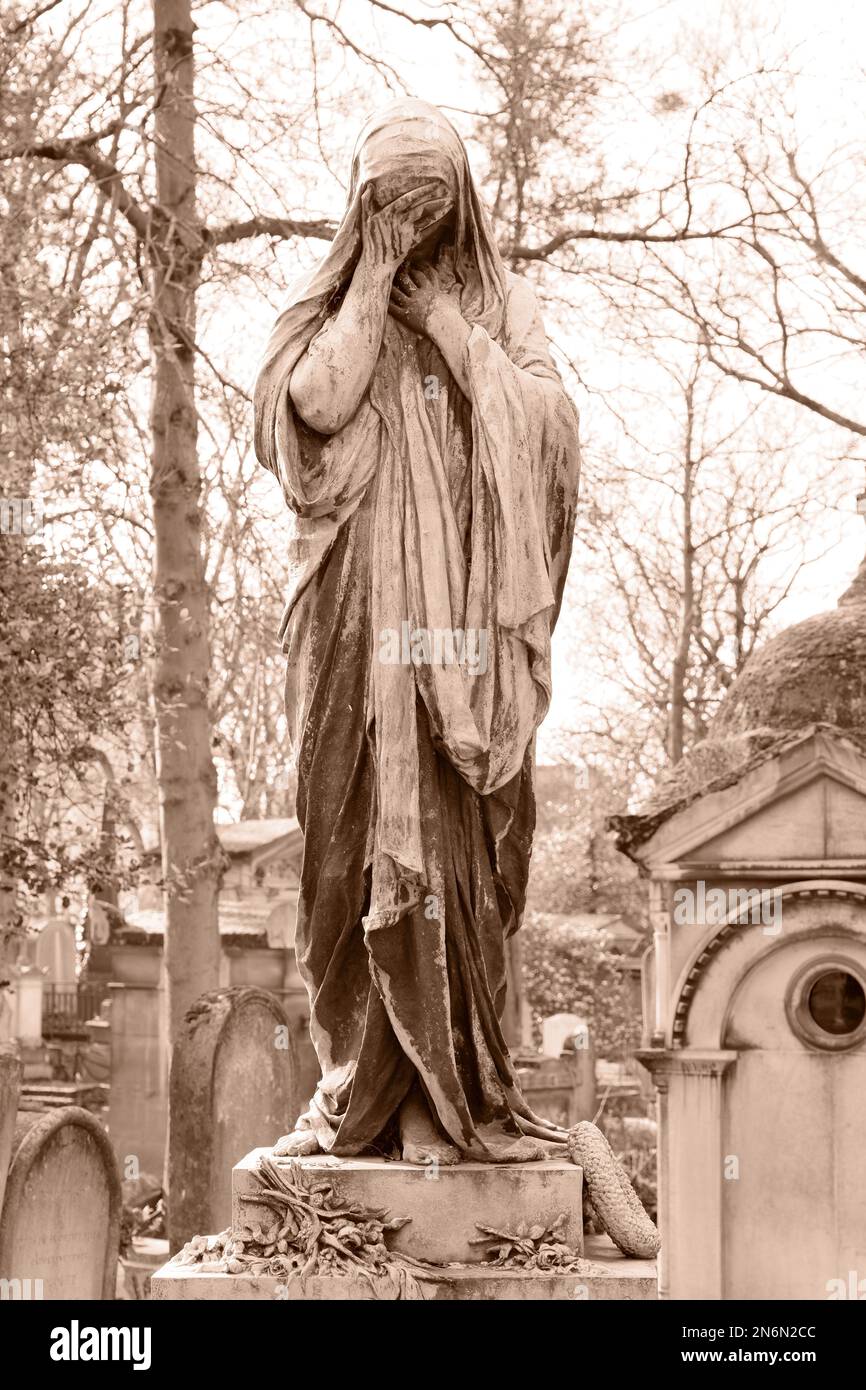 Weeping angel statue on a tomb in Pere Lachaise cemetery, Paris. Shot