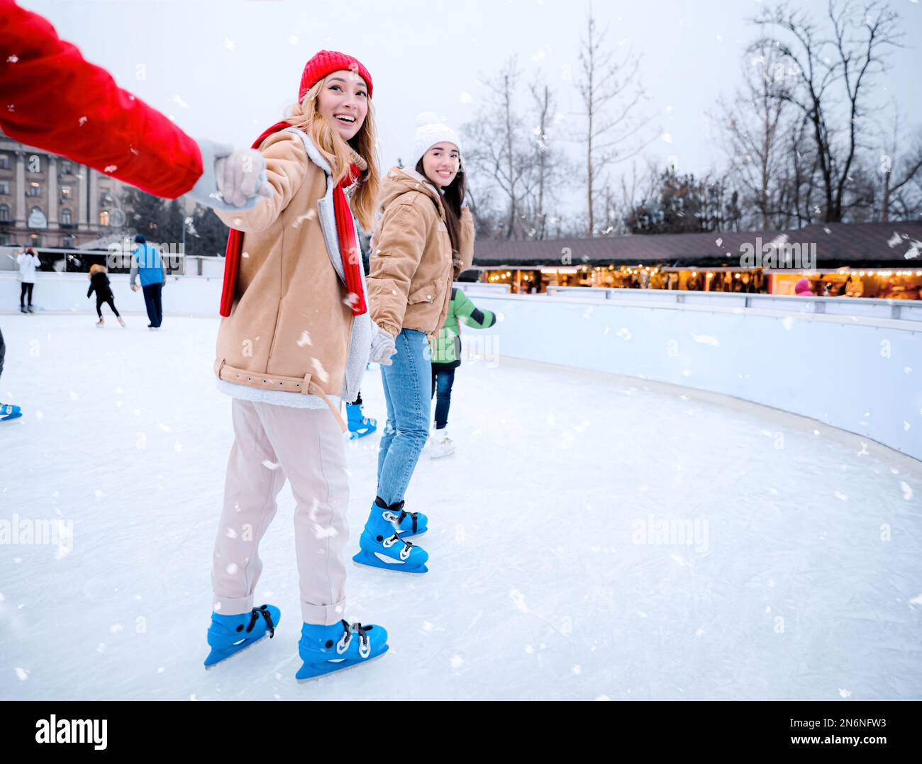 Group of friends skating at outdoor ice rink Stock Photo - Alamy