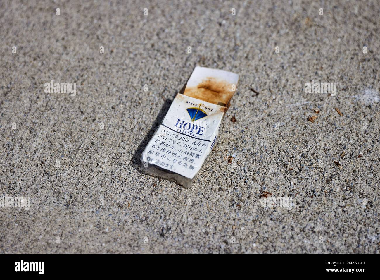 Hope (ホープ) cigarette pack, on the ground, discoloured; Japan Stock Photo