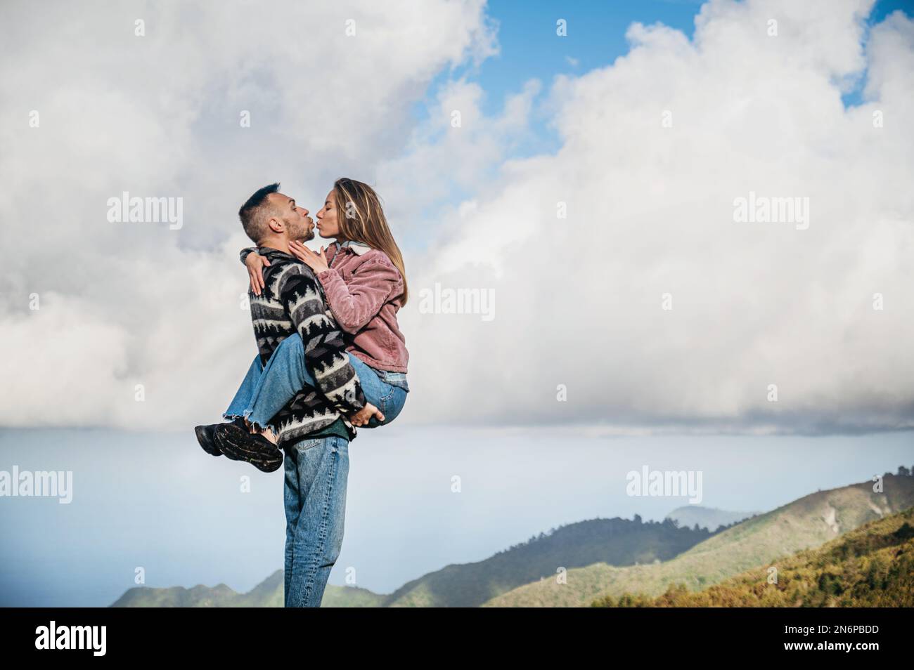 Couple kissing, with a clear blue sky as the background Stock Photo - Alamy