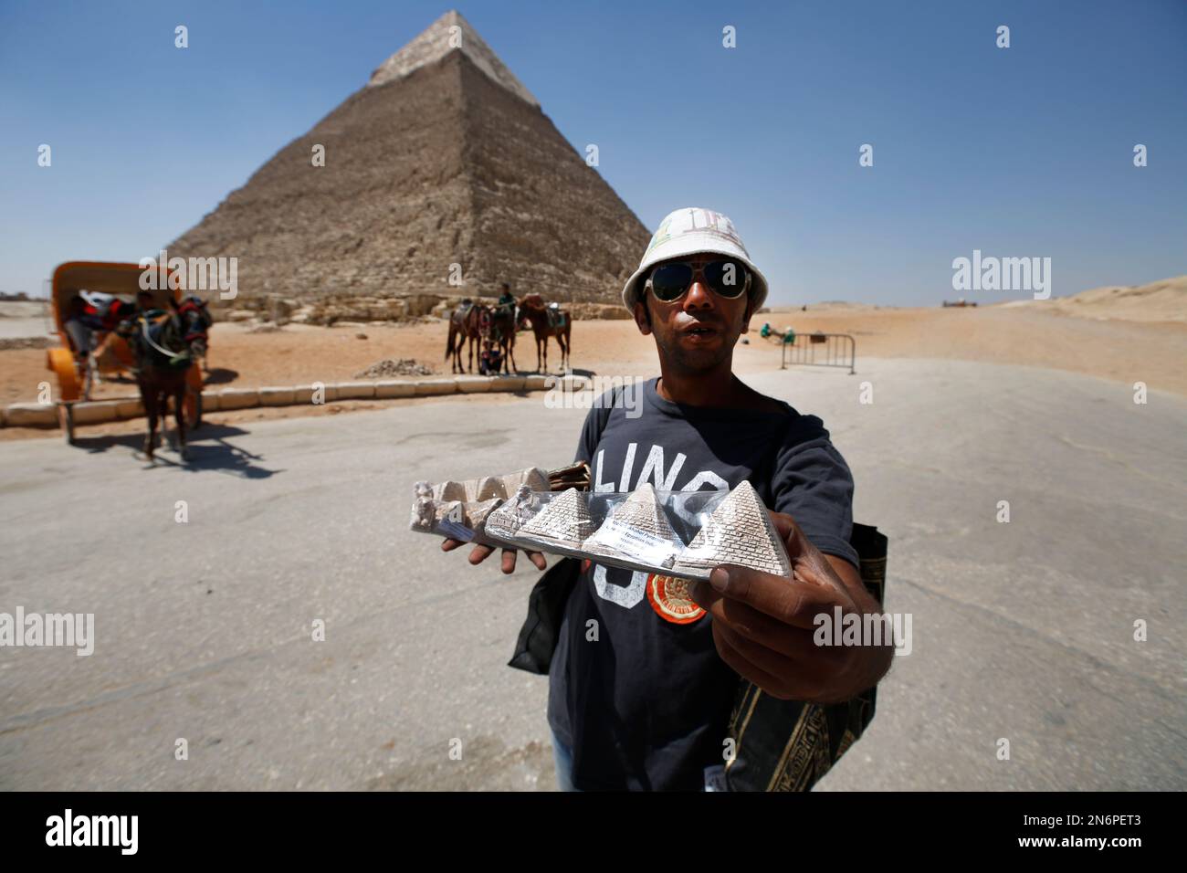 A vendor offers souvenirs for sale to tourists at the historical site of  the Giza Pyramids, near Cairo, Egypt, Saturday, Sept. 7, 2013. Riots and  killings after the ouster of President Mohammed
