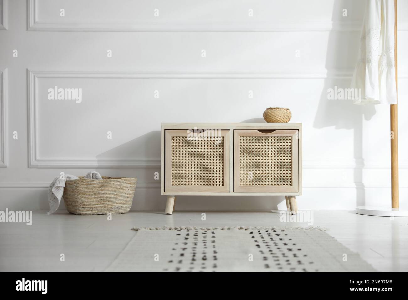 Wooden commode near white wall in room. Interior design Stock Photo Alamy
