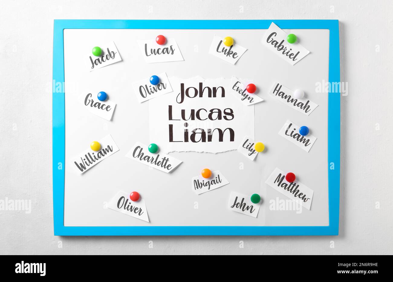 Board with baby names hanging on white wall Stock Photo Alamy