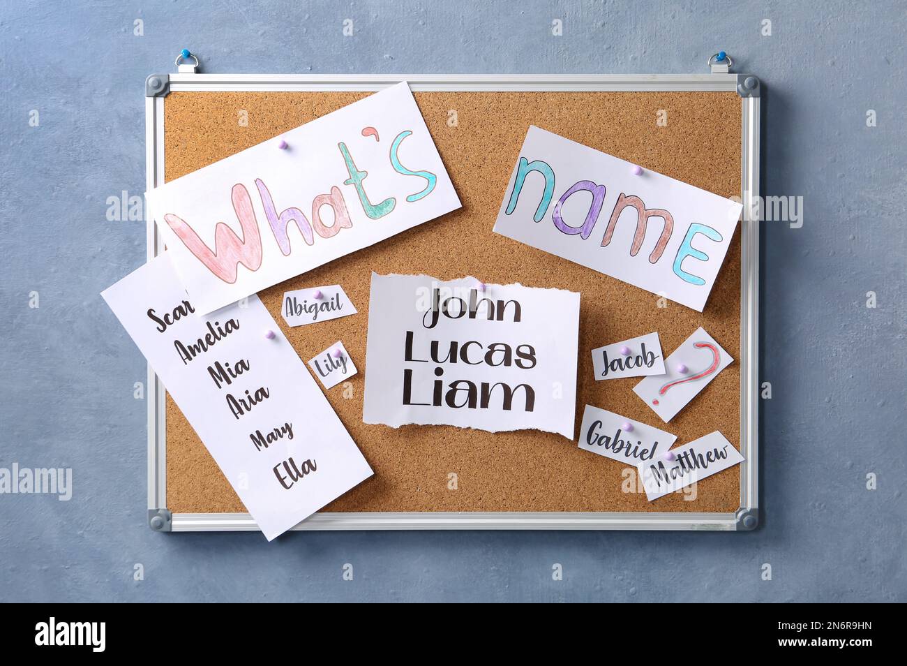 Cork board with baby names hanging on grey wall Stock Photo Alamy