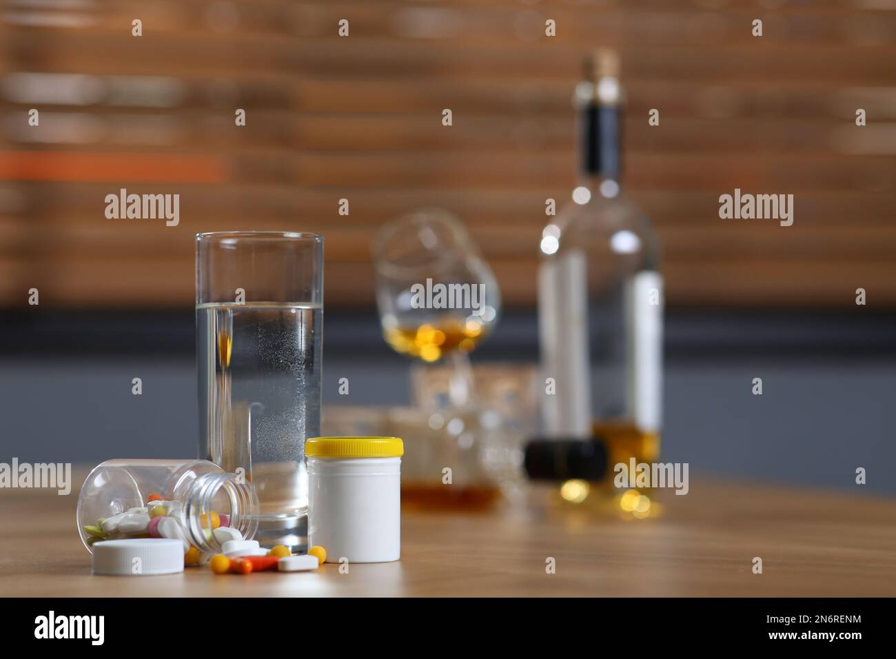 Glass of water, pills and alcohol on table indoors, space for text. Hangover remedy Stock Photo