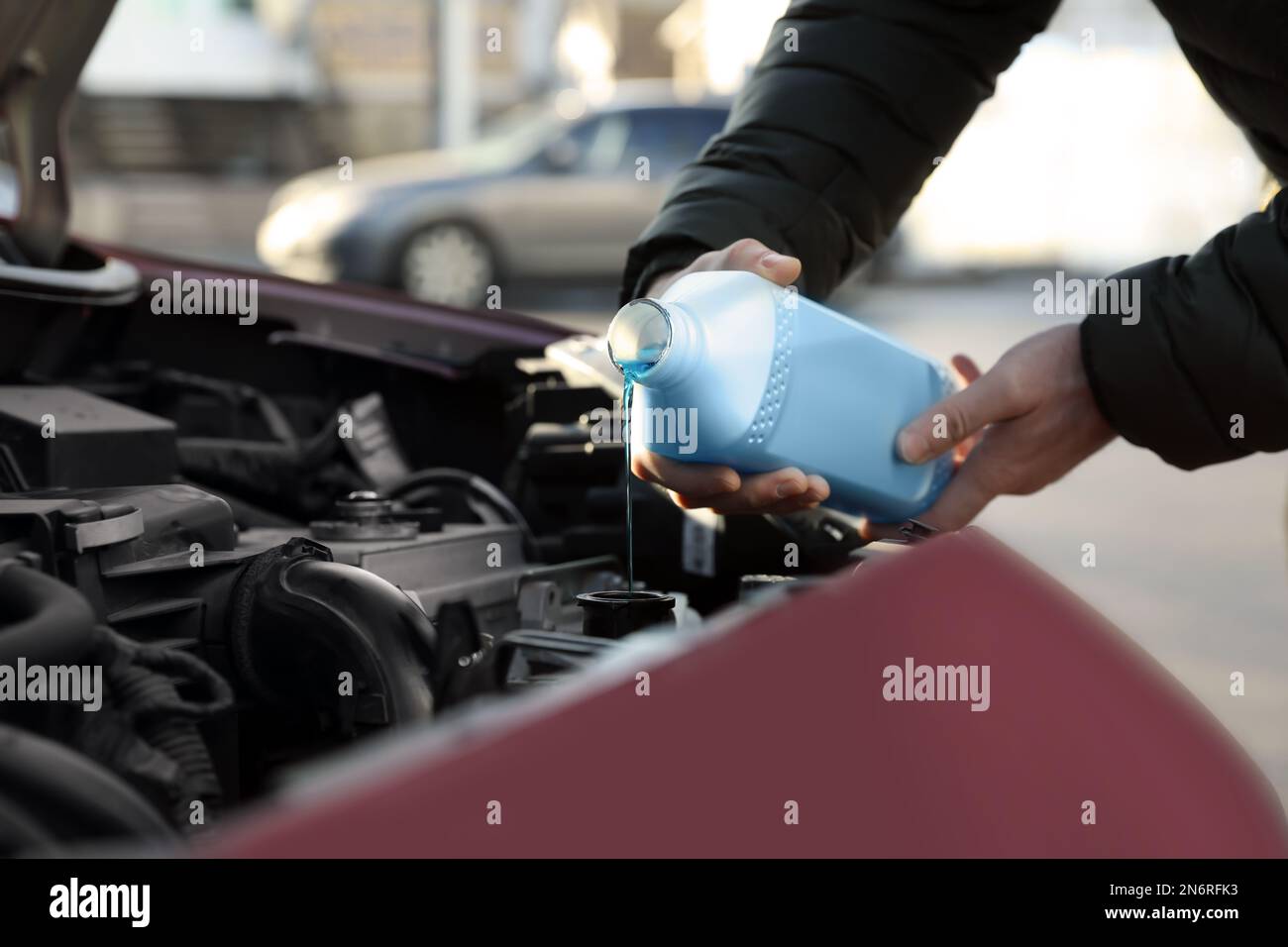 Man filling car radiator with antifreeze outdoors, closeup Stock Photo ...