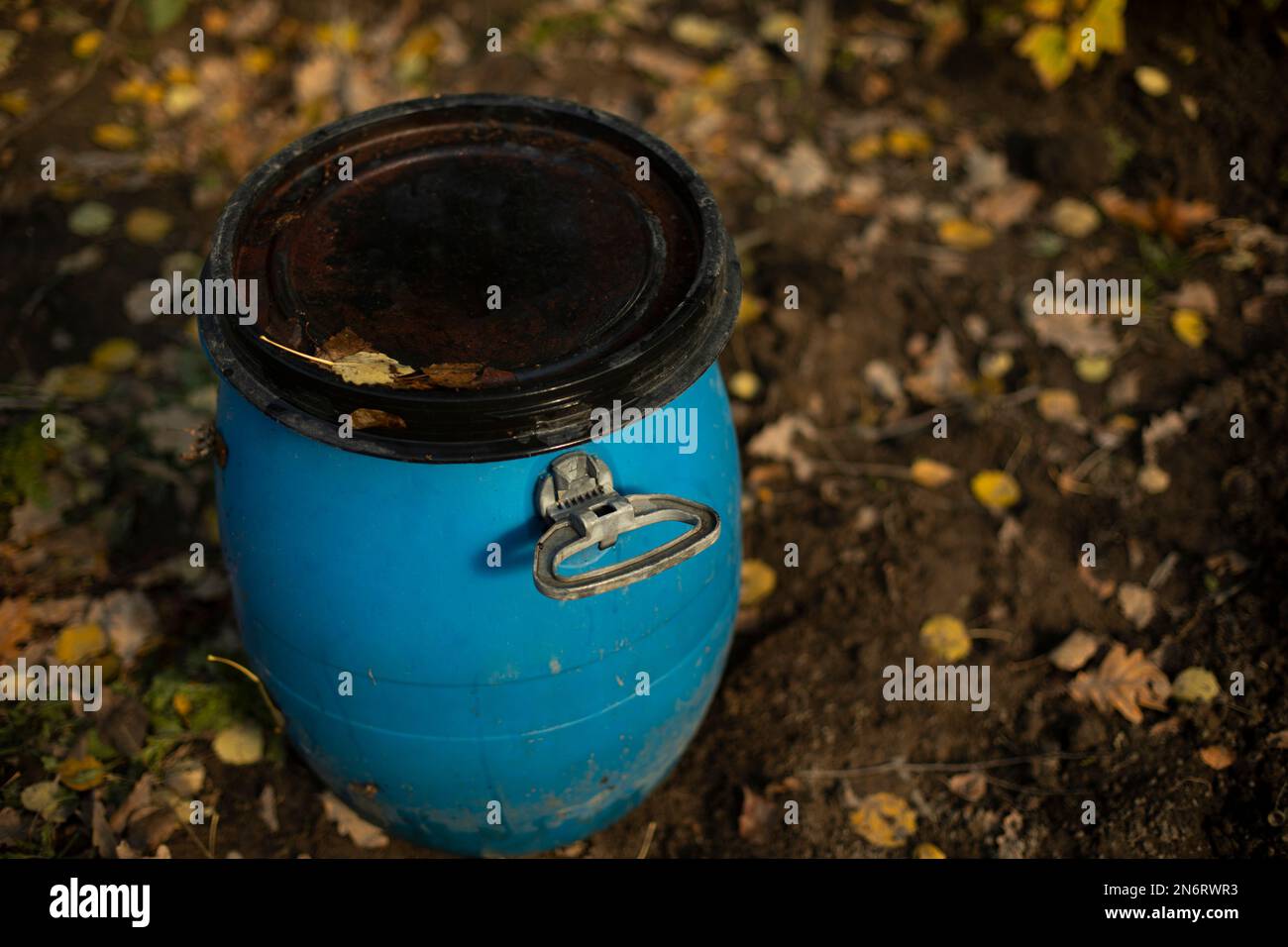 Blue barrel in garden. Water tank. Plastic barrel for watering plants