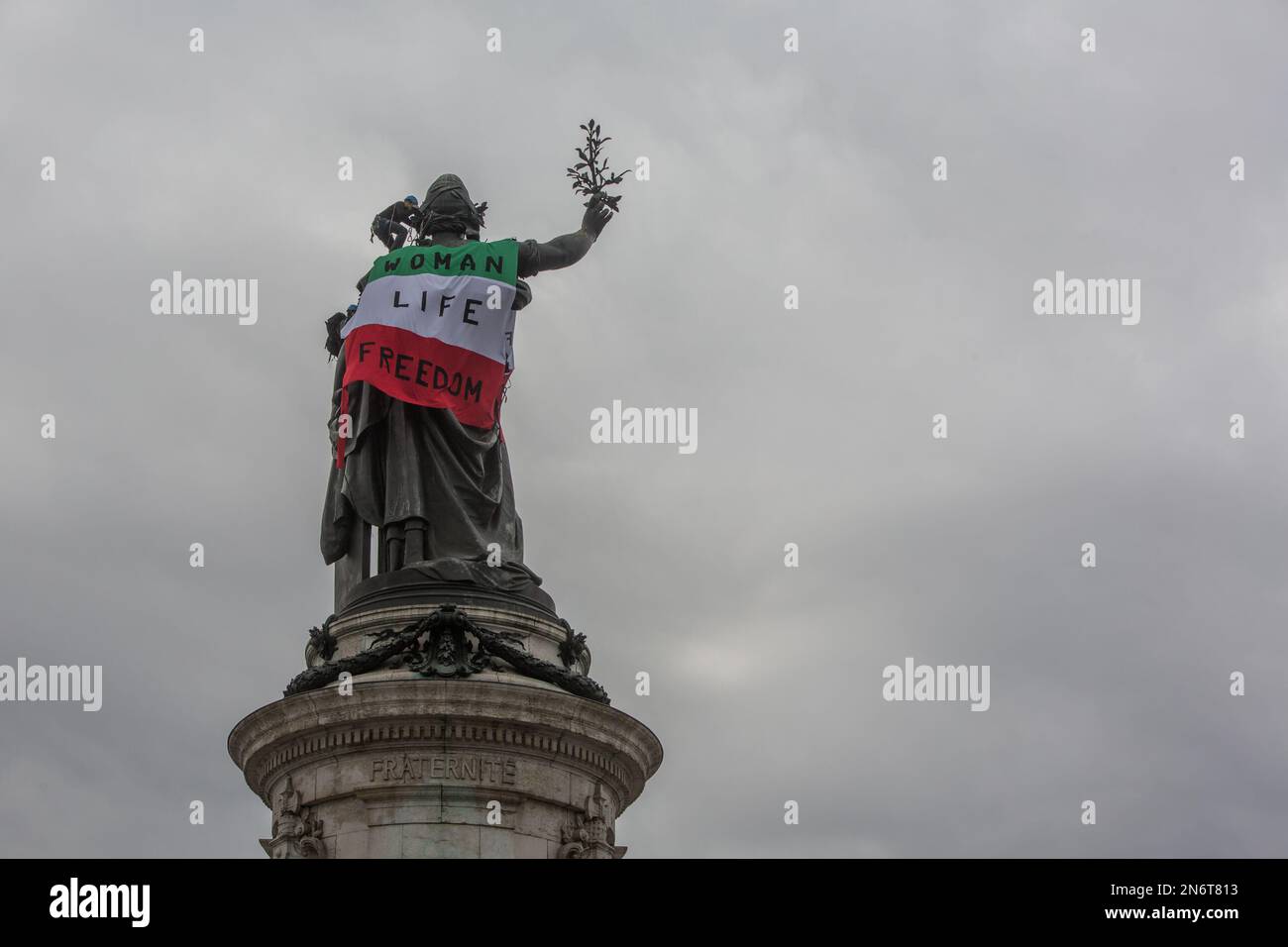 France / Paris  - 10/02/2023, Michael Bunel / Le Pictorium -  Action by extinction rebellion activists -  10/2/2023  -  France / Ile-de-France (region) / Paris  -  Rebellion extinction activists, in support of the Iranian protesters who have been opposing the government since the death of Masha Amini on September 16, 2022, place an Iranian flag on the statue in Republic Square. The action takes place on the 50th anniversary of the Iranian revolution that brought the mullahs' regime to power. 10 February 2023. Paris, France. Stock Photo