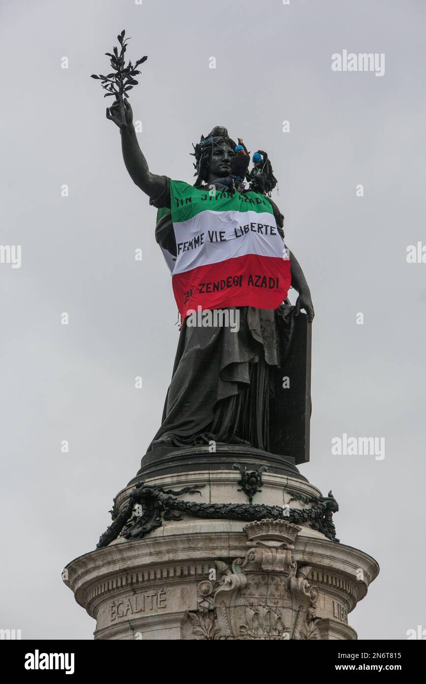 France / Paris  - 10/02/2023, Michael Bunel / Le Pictorium -  Action by extinction rebellion activists -  10/2/2023  -  France / Ile-de-France (region) / Paris  -  Rebellion extinction activists, in support of the Iranian protesters who have been opposing the government since the death of Masha Amini on September 16, 2022, place an Iranian flag on the statue in Republic Square. The action takes place on the 50th anniversary of the Iranian revolution that brought the mullahs' regime to power. 10 February 2023. Paris, France. Stock Photo