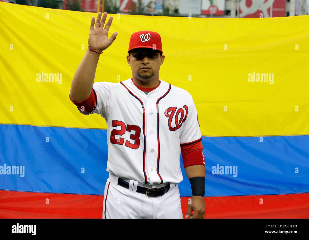Washington Nationals catcher Jhonatan Solano (23) stands in front of the  Columbian flag before a baseball