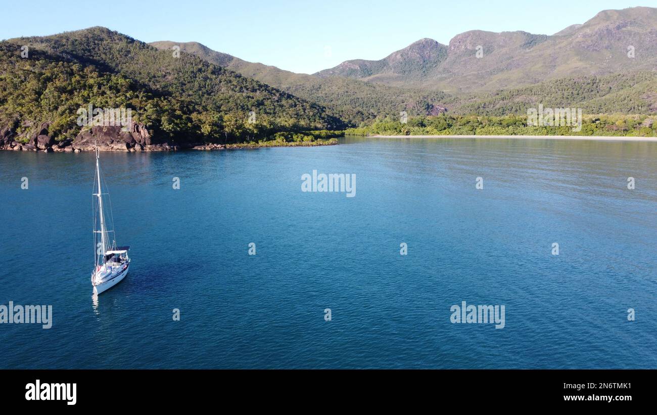Sailing boat anchored in Zoe Bay with tropical Hinchinbrook Island