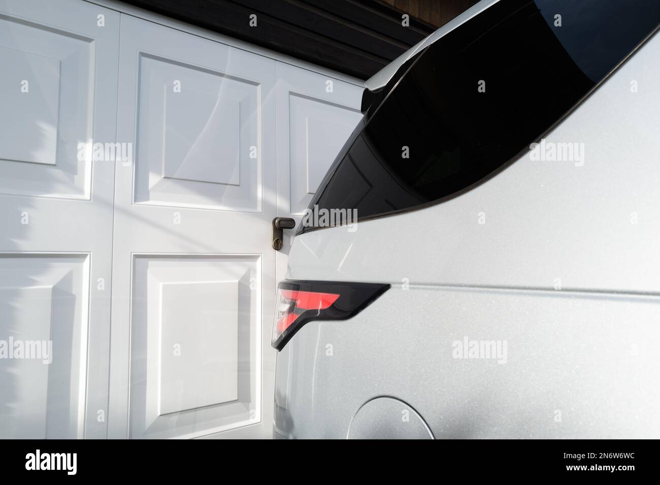 Abstract view of a parked SUV on a driveway close to garage doors