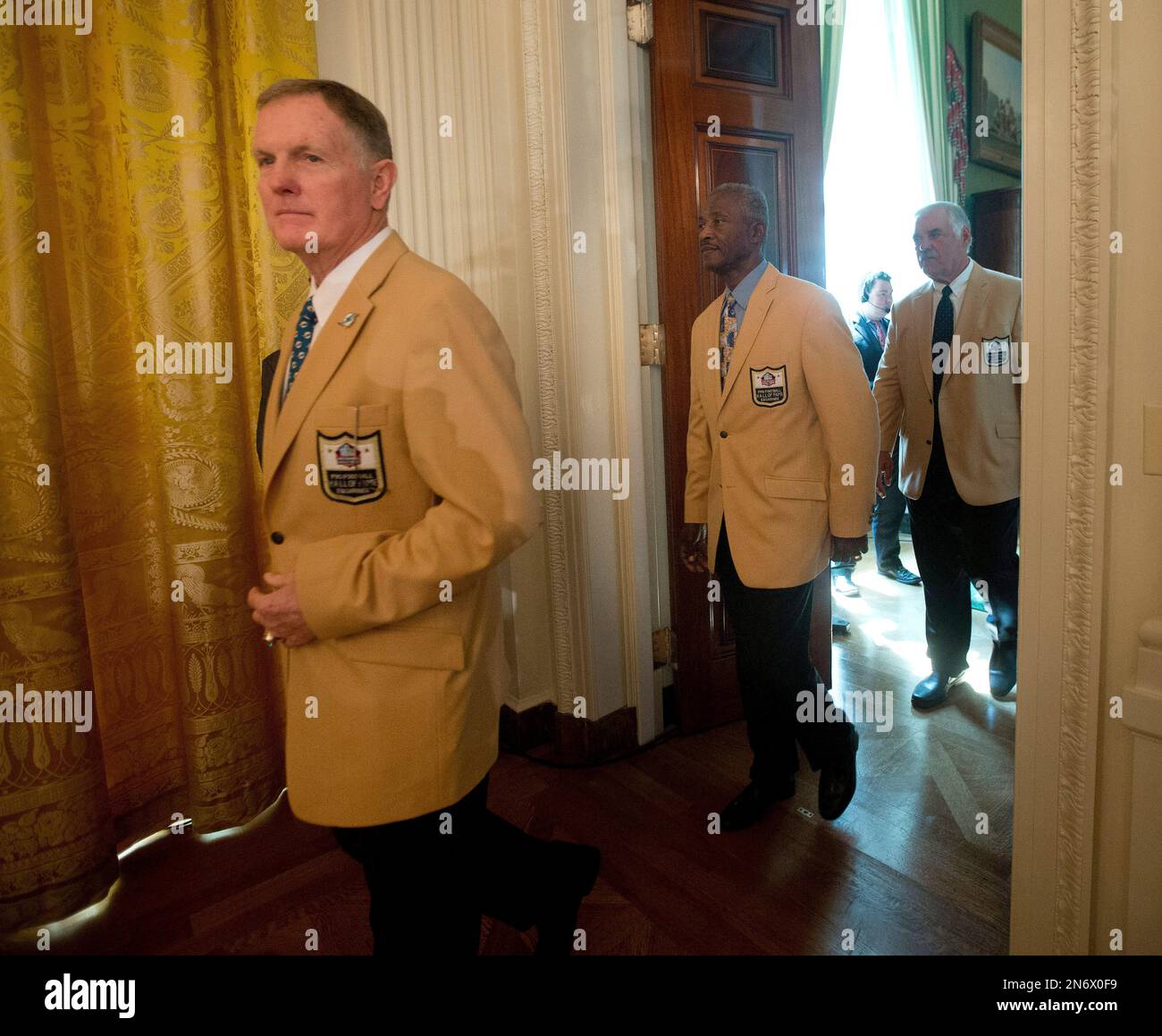 President Barack Obama jokes with members of the 1972 Miami Dolphins,  including offensive guard Larry Little (L), and quarterback Bob Griese,  during a ceremony honoring the Super Bowl VII Champions and their