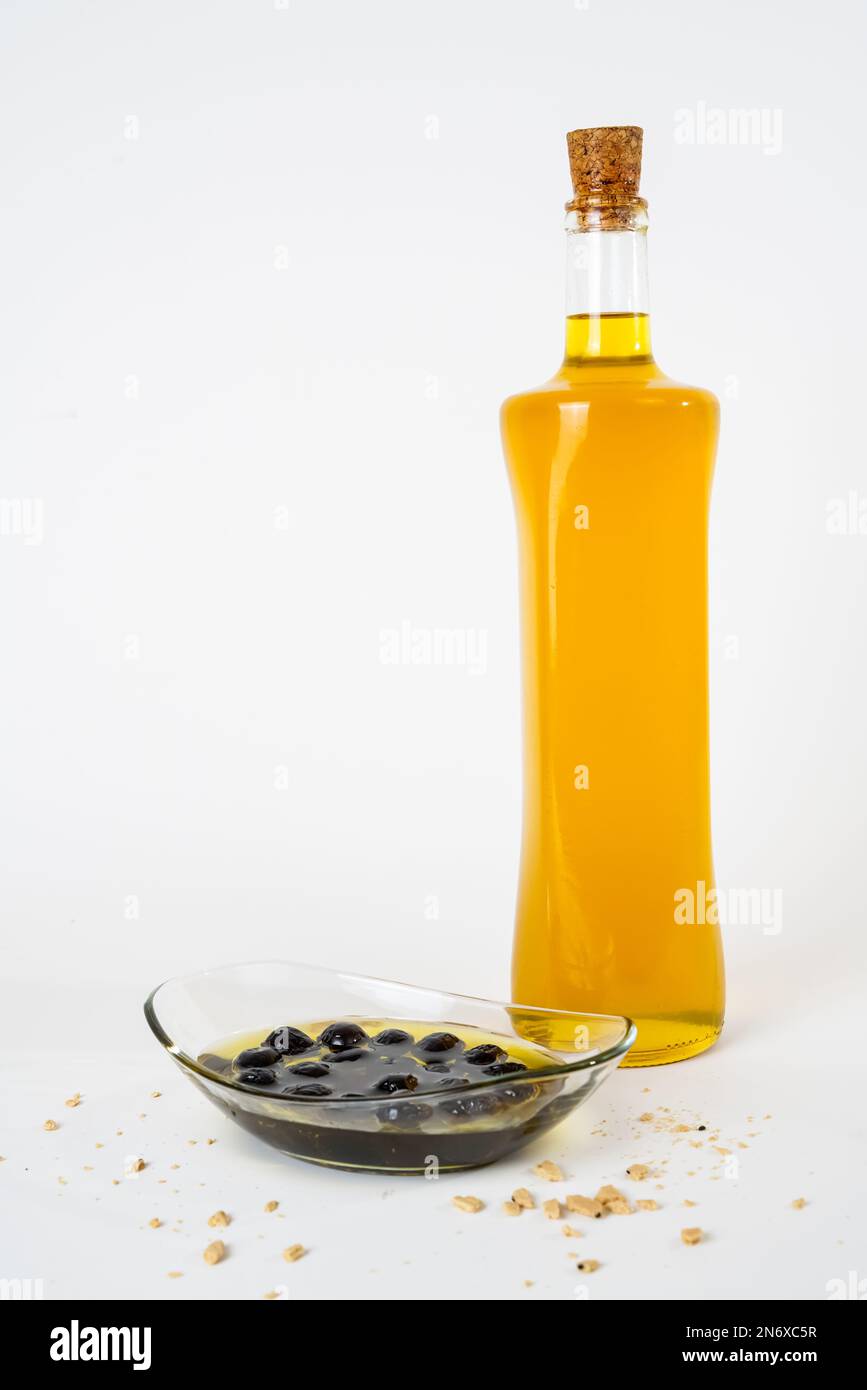 Glass bottle of olive oil and pickled black olives isolated on white ...