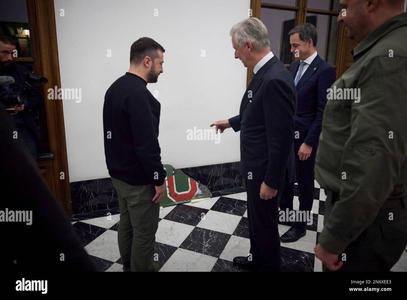 Brussels, Belgium. 09th Feb, 2023. Ukrainian President Volodymyr Zelenskyy, left, presents King Philippe of Belgium, center, with a fragment of a Russian Su-25 aircraft shot down by Ukrainian pilots at the Royal Palace, February 9, 2023 in Brussels, Belgium. Credit: Pool Photo/Ukrainian Presidential Press Office/Alamy Live News Stock Photo