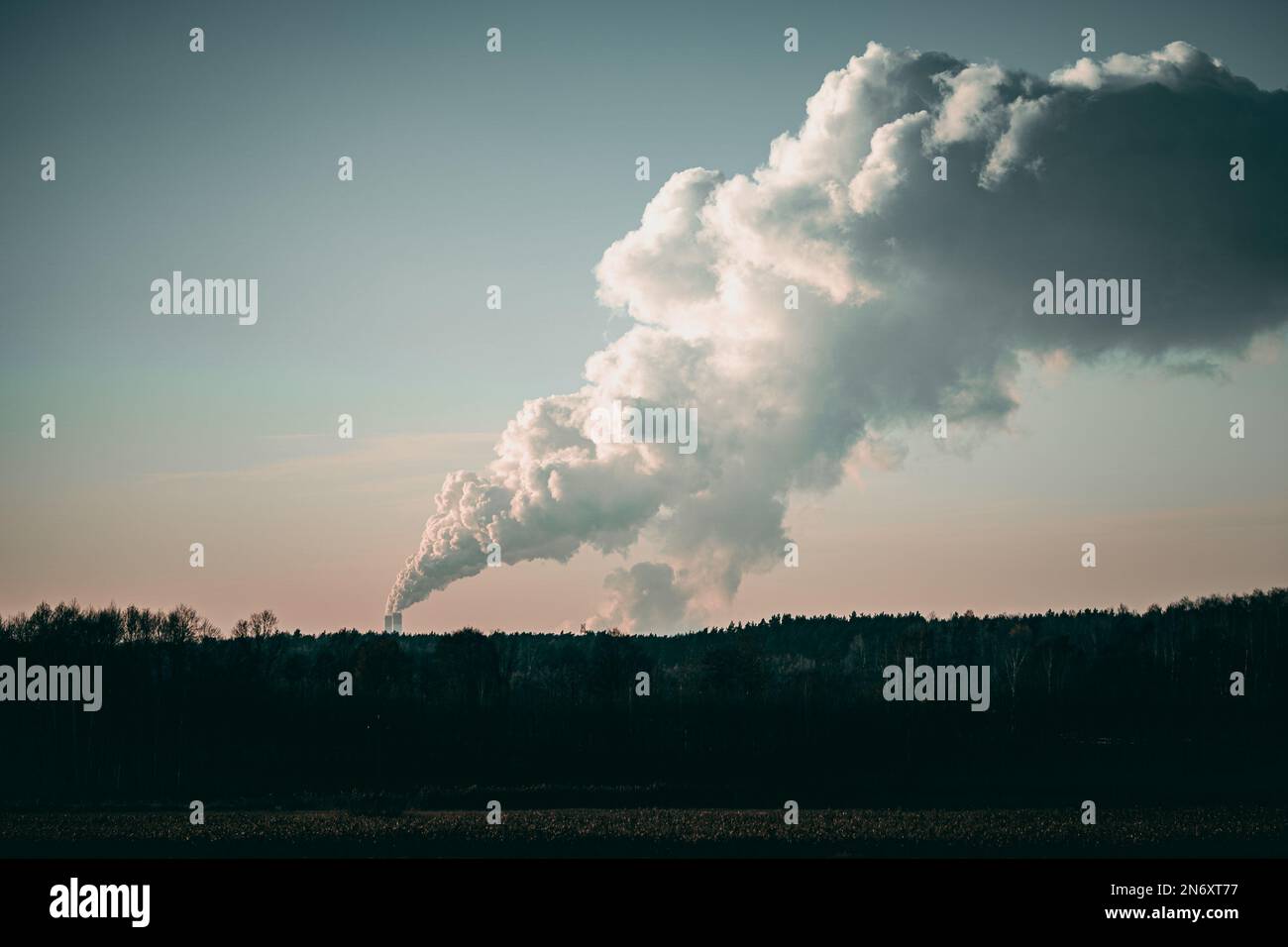A beautiful shot of smoke coming out of industrial chimneys on a rural valley Stock Photo