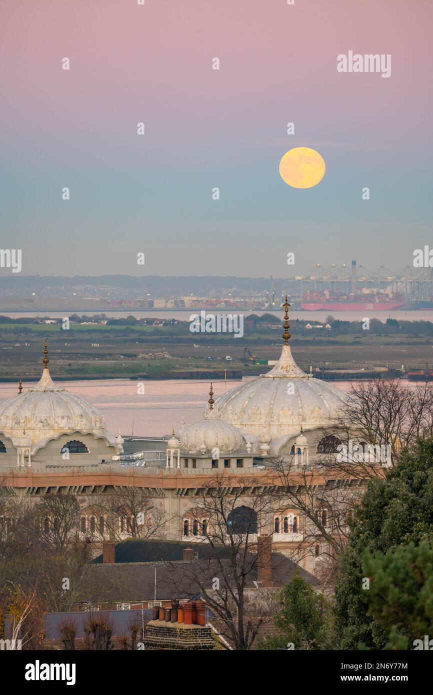 Full moon rising above the DP World London Gateway Port with the Siri Guru Nanak Darbar Gurdwara in Gravesend From windmill hill. Stock Photo