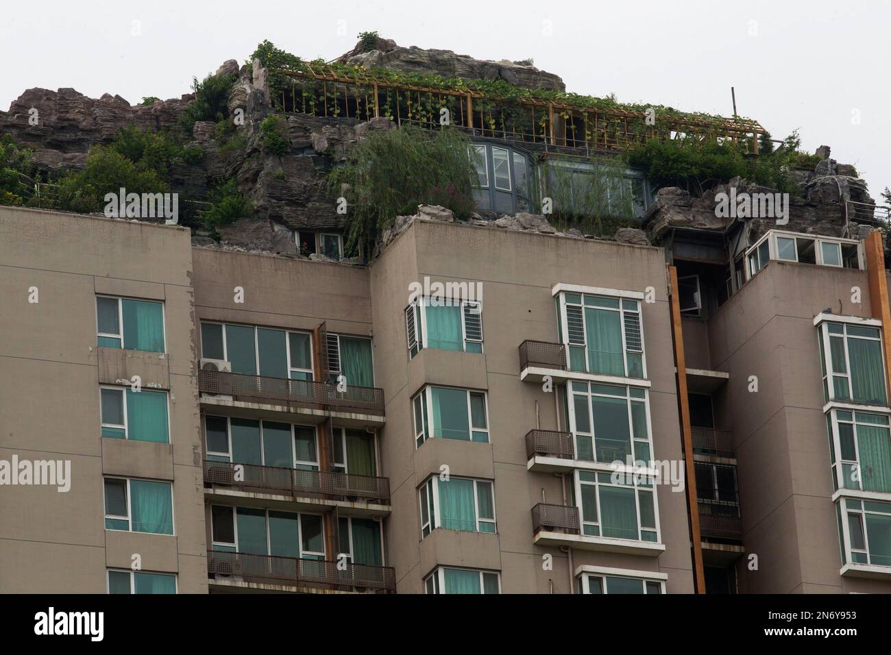 A rooftop villa complete with rocks and flora built on top of a high ...