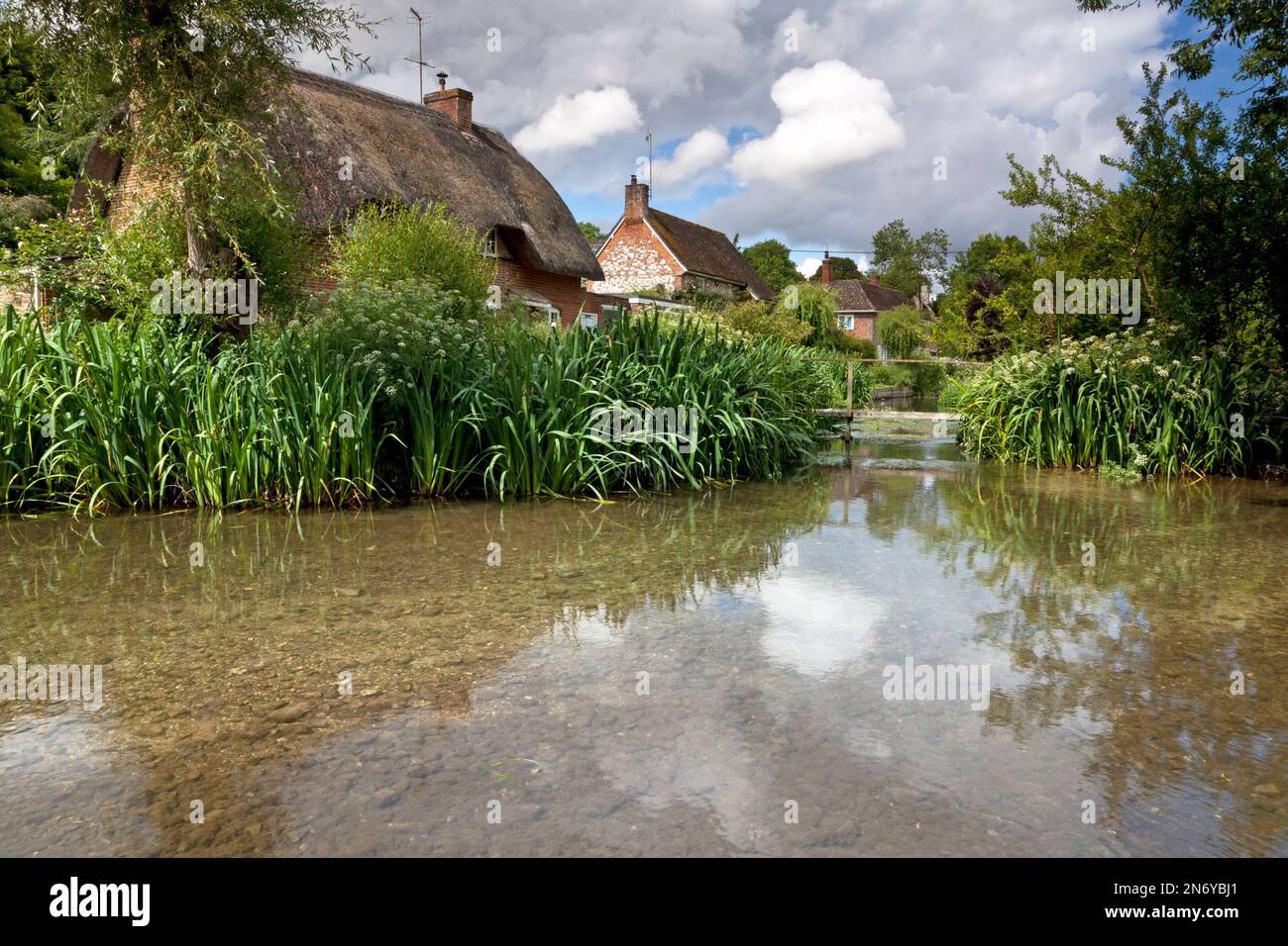 Cottages beside the River Ebble in the village of Stratford Tony, near Salisbury in Wiltshire. Stock Photo