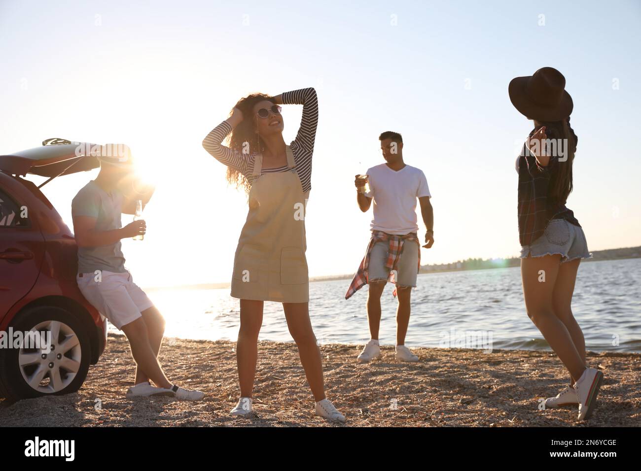 Happy friends having fun near car on beach. Summer trip Stock Photo - Alamy