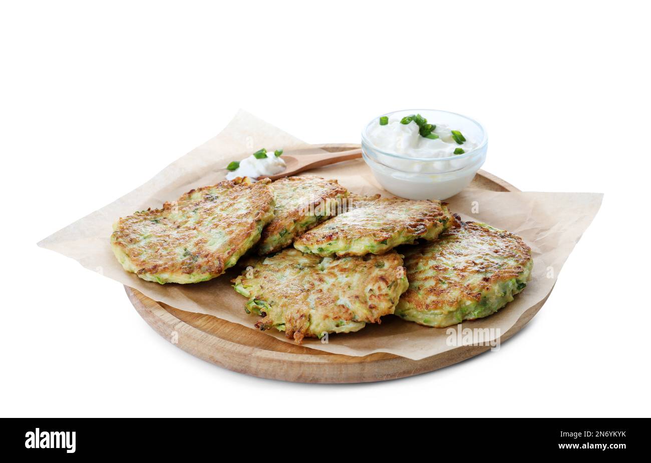 Delicious zucchini fritters with sour cream on white background Stock Photo