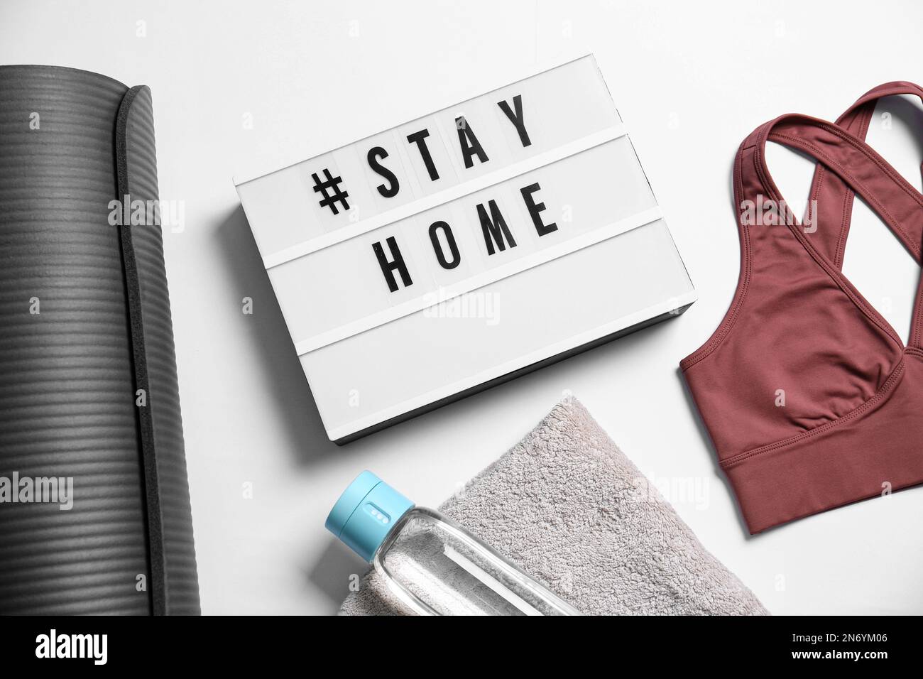 Stylish sportswear, yoga mat and light box with hashtag Stay at Home on  white background, flat lay. Self isolation during COVID‑19 pandemic Stock  Photo - Alamy