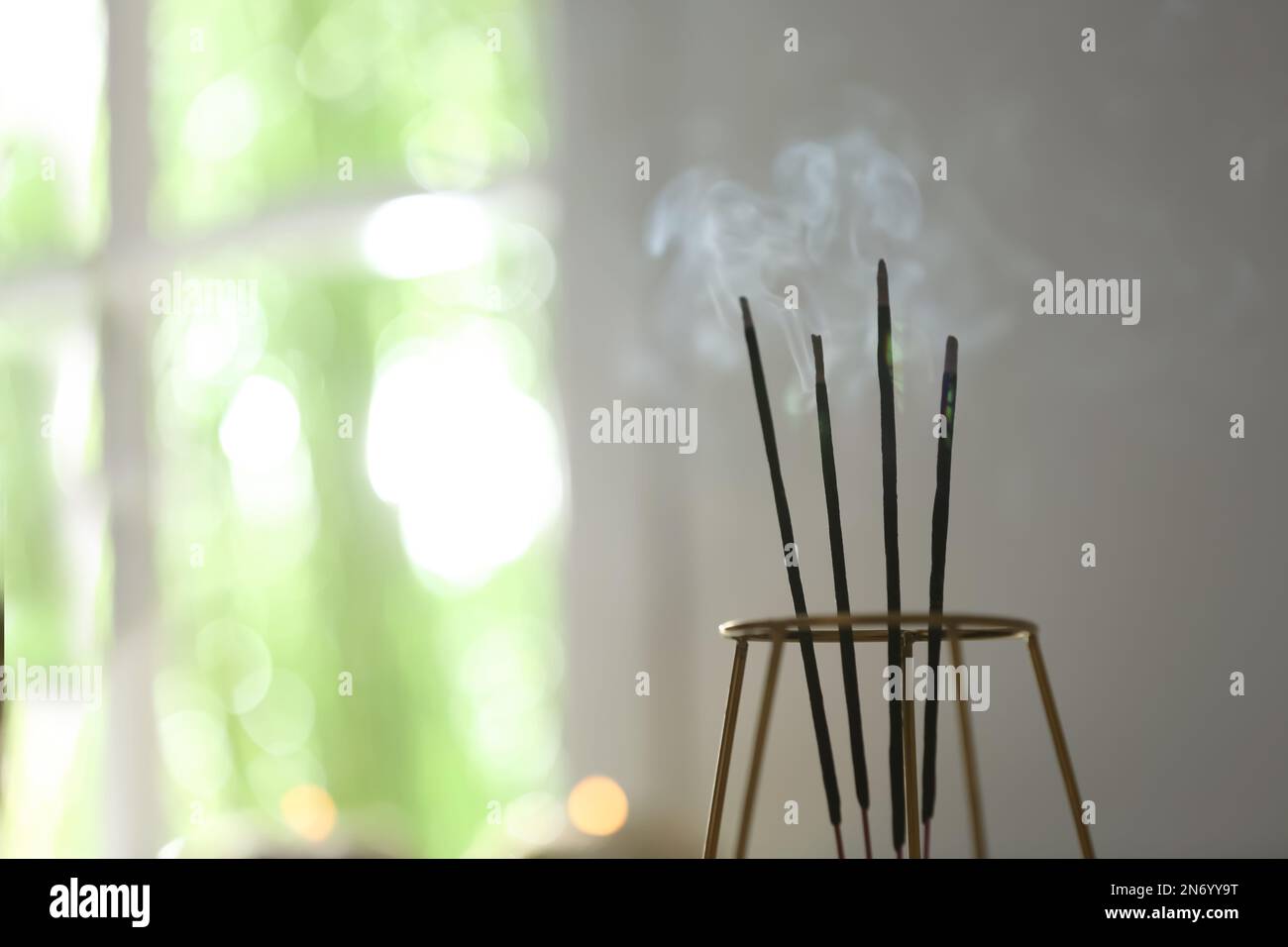 Incense sticks smoldering on blurred background, closeup. Space for ...