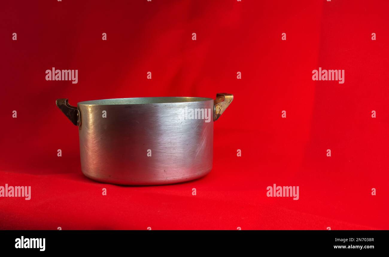 an-old-aluminum-pan-made-in-circa-1960-against-a-red-background-stock