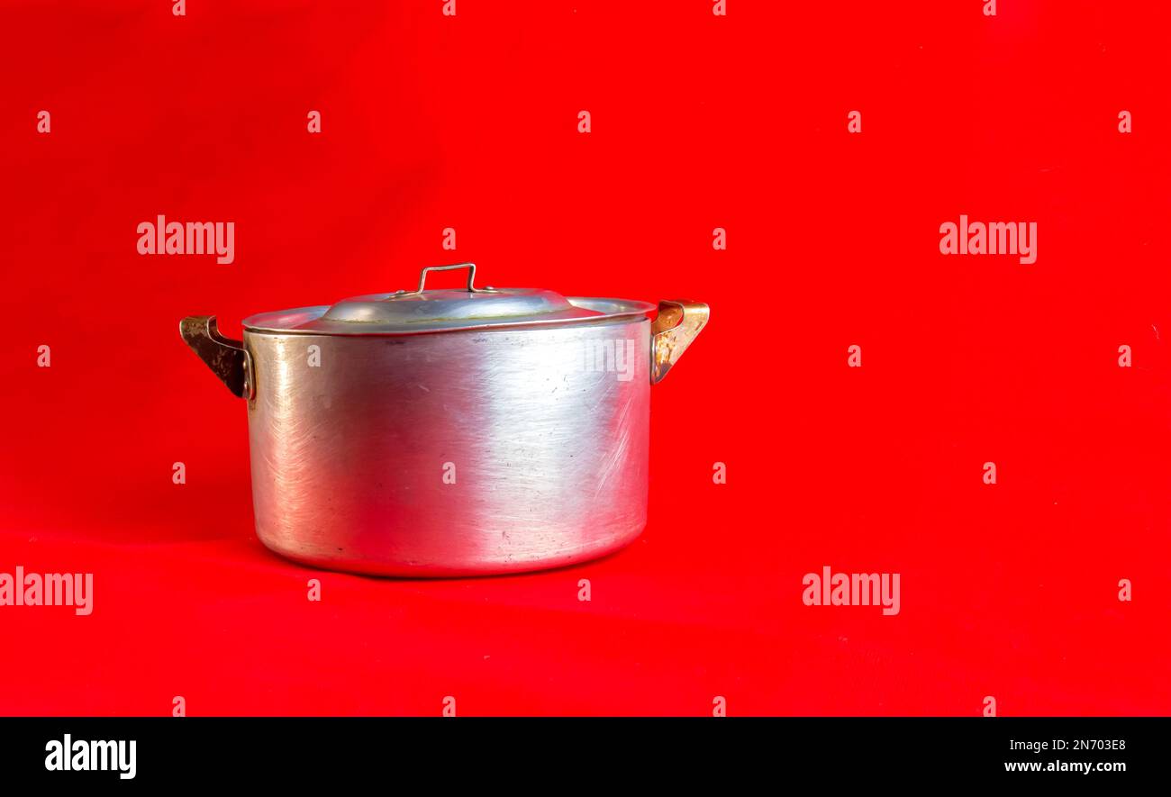 An old aluminum pan made in circa 1960 against a red background Stock